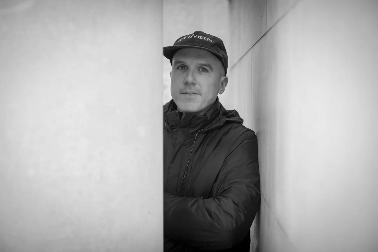 Black and white portrait of a dance instructor against a light background.