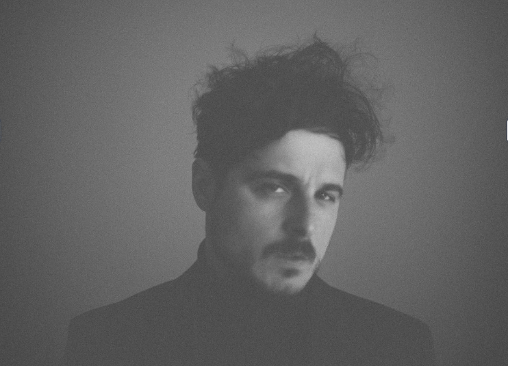 Black and white portrait of a dance instructor against a light background.